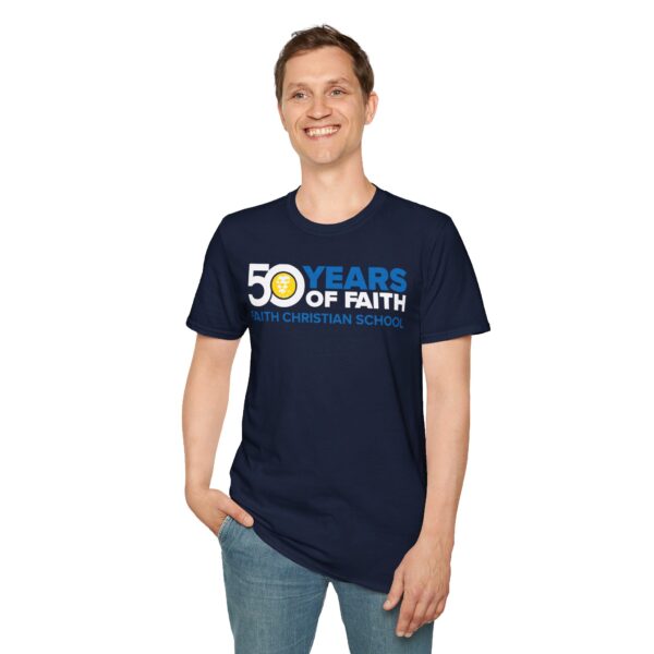 A smiling man wearing a dark blue T-shirt with the text "50 YEARS OF FAITH - FAITH CHRISTIAN SCHOOL" on it, standing against a white background.